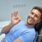 Joyful brunette man smiling at the dentist office