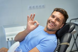 Joyful brunette man smiling at the dentist office
